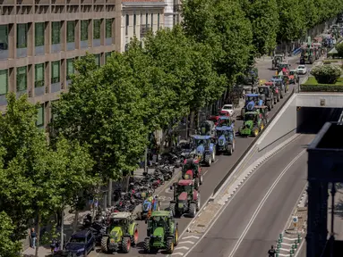 Para petani mengemudikan traktor mereka selama protes di jalan-jalan Madrid, Spanyol, Rabu (5/7/2023). (AP Photo/Manu Fernandez)