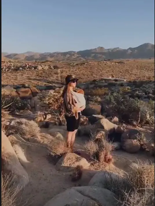 <p>Menikmati matahari pagi, Nikita Willy menggendong Baby Issa dengan mengenakan atasan berwarna cokelat dan celana pendek berwarna hitam. (instagram/indpriw)</p>