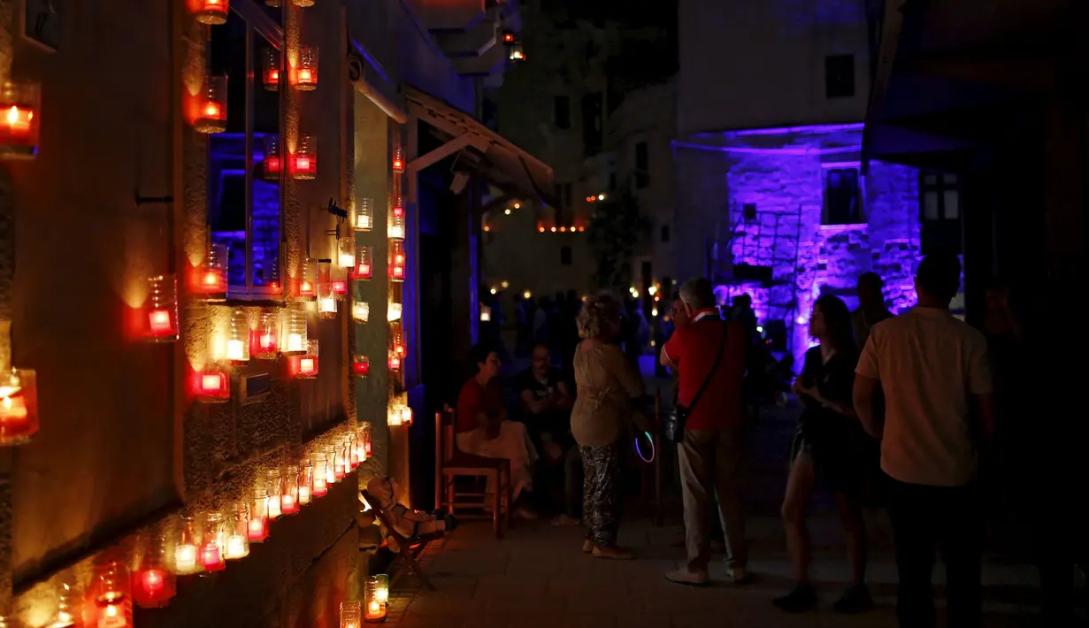 Para wisatawan menikmati keindahan lilin - lilin saat digelarnya festival Birgu di Malta, Sabtu (10/10/2015). Festival ini bertujuan memberikan sentuhan magis terhadap kota yang dulunya merupakan rumah pertama Knights of St John. (REUTERS/Darrin Zammit)