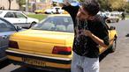 Seorang sopir taksi Iran mendinginkan diri dengan menyiramkan air ke wajahnya di sebuah jalan di tengah suhu yang melonjak di Teheran pada 22 Juli 2025. (Foto oleh AFP)