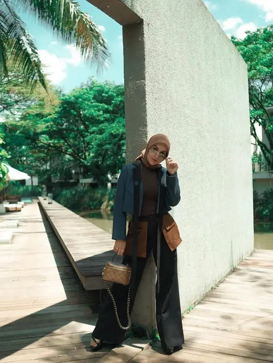 Kali ini, Irish Bella tampil bergaya ala cewek mamba dengan padu padan cropped blazer hitam, pants with socket nuansa warna coklat-hitam, plus hijab warna coklat. Kece banget!  (Instagram/_irishbella_).