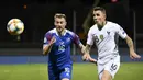 Gelandang Islandia, Runar Mar Sigurjonsson, beradu cepat dengan bek Prancis, Lucas Digne, pada laga Kualifikasi Piala Eropa 2020 di Reykjavik, Sabtu (11/10). Islandia kalah 0-1 dari Prancis. (AFP/Jonathan Nackstrand)