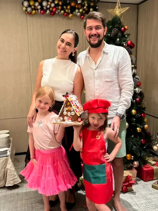 Marissa Nasution telah membagikan foto di depan pohon natal bersama suami dan kedua putrinya. Marissa tampil mengenakan atasan putih sleeveless dipadukan rok hitam. [@marissaln]