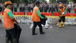 Petugas PPSU membersihkan sampah sisa perayaan Hari Buruh Internasional di kawasan Silang Barat Daya Monas, Jakarta, Rabu (1/5). Sampah yang berserakan di kawasan tersebut membuat Petugas PPSU bekerja ekstra keras untuk membersihkan kawasan tersebut. (Liputan6.com/Helmi Fithriansyah)
