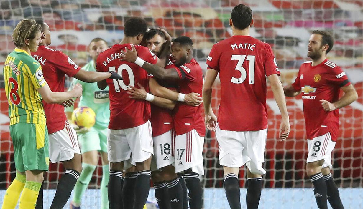 Para pemain Manchester United merayakan gol yang dicetak oleh Bruno Fernandes ke gawang West Bromwich Albion pada laga Liga Inggris di Stadion Old Trafford, Minggu (22/11/2020). MU menang dengan skor 1-0. (Martin Rickett/Pool via AP)
