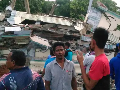 Warga mengamati sebuah bangunan yang roboh menyusul gempa 6,4 SR di Kabupaten Pidie Jaya, Aceh, Rabu (7/12). Sejumlah bangunan di Kabupaten Pidie Jaya rusak akibat gempa yang tak berpotensi tsunami tersebut. (Zian Muttaqien/AFP)