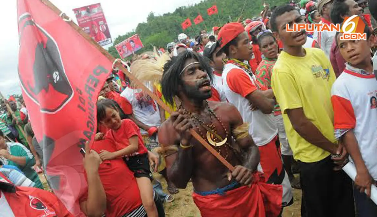 Salah satu peserta kampanye yang memakai pakaian tradisional Papua tampak larut dalam suasana kampanye (Liputan6.com/Herman Zakharia)