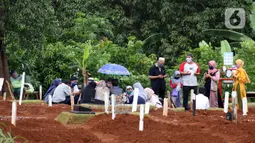 Peziarah berdoa di sisi makam jenazah yang diduga terinfeksi virus COVID-19 di TPU Pondok Ranggon, Jakarta, Minggu (24/5/2020). Momen Hari Raya Idul Fitri 1441 H dimanfaatkan sejumlah keluarga dan kerabat korban yang diduga terinfeksi COVID-19 untuk berziarah. (Liputan6.com/Helmi Fithriansyah)