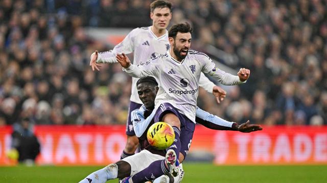 Gelandang Manchester United, Bruno Fernandes, dibekap cedera saat timnya kalah 1-2 dari Aston Villa pada laga pekan ke-17 Premier League di Villa Park, Minggu (21/12/2025) malam WIB. (AFP/Ben STANSALL)