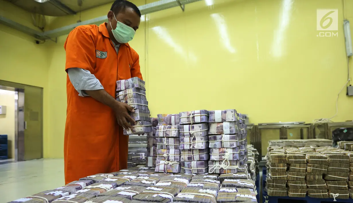 Petugas menata tumpukan uang kertas di Cash Center Bank BNI di Jakarta, Kamis (6/7). Nilai tukar rupiah terhadap dolar Amerika Serikat (USD) pada sesi I perdagangan hari ini masih tumbang di kisaran level Rp13.380/USD. (Liputan6.com/Angga Yuniar)
