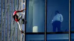 Alain Robert yang dikenal sebagai 'Spiderman Prancis' (kiri) memanjat gedung pencakar langit Skyper di pusat Frankfurt, Jerman, 23 November 2021. Alain Robert memanjat gedung setinggi 153 meter itu untuk meningkatkan kesadaran dunia tentang masalah perubahan iklim. (AP Photo/Michael Probst)