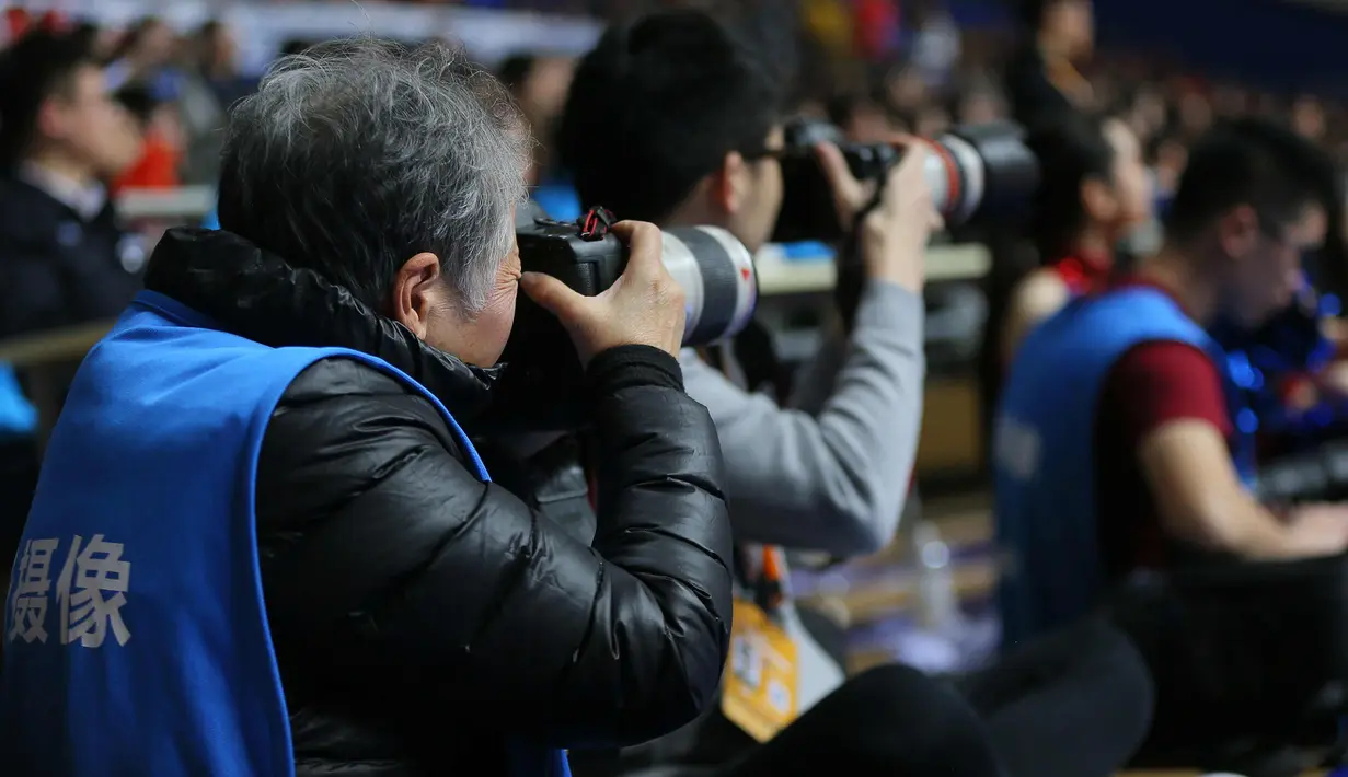 Fotografer Hong Nanli mengambil gambar selama pertandingan bola basket di Shanghai, China (16/1). Nenek Hong Nanli gemar berolah raga 3 kali seminggu, dan masih aktif menjadi fotografer paruh waktu. (AFP Photo/China Out)
