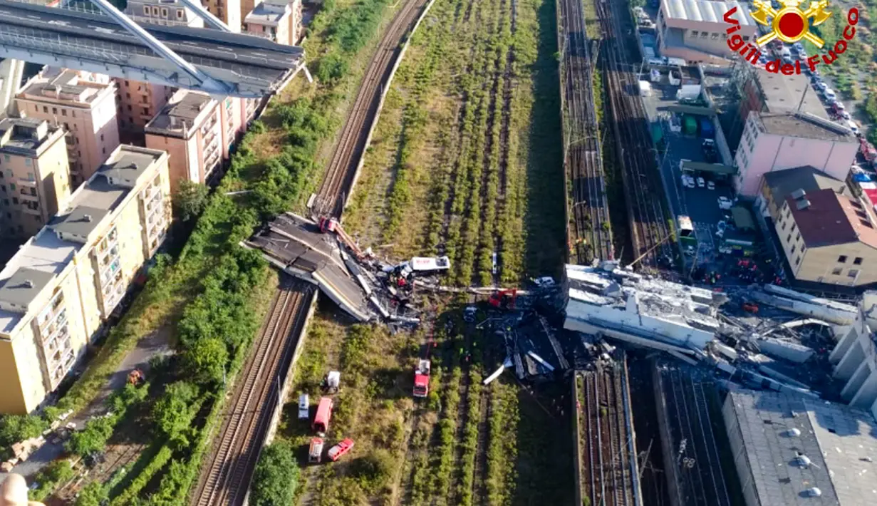 Tim penyelamat berada di antara puing-puing jembatan jalan raya Morandi yang ambruk di Genoa, Italia, Selasa (14/8). Hanya 100 meter dari total satu kilometer panjang jembatan tersebut yang dilaporkan ambruk. (Vigili Del Fuoco via AP)