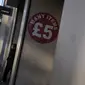 Seorang pria berjalan keluar dari gerai pakaian diskon di Oxford Street di London, Rabu (16/11/2022). Inflasi telah membuat pasar tenaga kerja Inggris tertekan. Diperkirakan para buruh akan meminta kenaikan gaji demi bisa mengimbangi inflasi. (AP Photo/Alastair Grant)