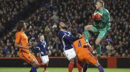 Aksi kiper Belanda, Jasper Cillessen mengamankan bola dari kejaran pemain Skotlandia pada laga persahabatan di Pittodrie, Aberdeen, Skotlandia (9/11/2017). Belanda menang 1-0. (Andrew Milligan/PA via AP)