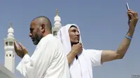 Jemaah haji mengambil foto diri atau selfie mereka di kota suci Makkah. (VOA News)