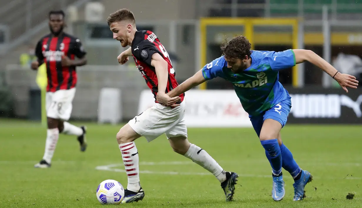 Pemain AC Milan Alexis Saelemaekers (kiri) memperebutkan bola dengan pemain Sassuolo Federico Peluso pada pertandingan Serie A di Stadion San Siro, Milan, Italia, Rabu (21/4/2021). AC Milan kalah 1-2 dari Sassuolo. (AP Photo/Antonio Calanni)
