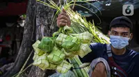 Pedagang menunjukkan cangkang ketupat di kawasan Palmerah, Jakarta, Minggu (18/7/2021). Pemberlakuan PPKM Darurat membuat penjualan cangkang ketupat jelang Idul Adha tahun ini sepi pembeli. (Liputan6.com/Faizal Fanani)
