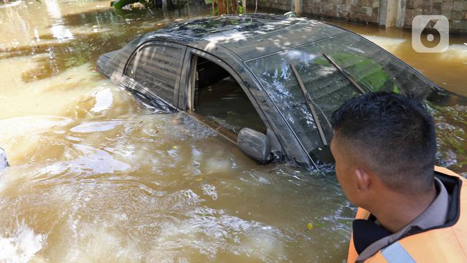 Sebuah mobil terendam banjir yang melanda kawasan Pela Mampang Pulo, Jakarta, Kamis (2/1/2020). Sejumlah rumah di kawasan Pela Mampang Pulo terpantau masih terendam banjir. (Liputan6.com/Herman Zakharia)