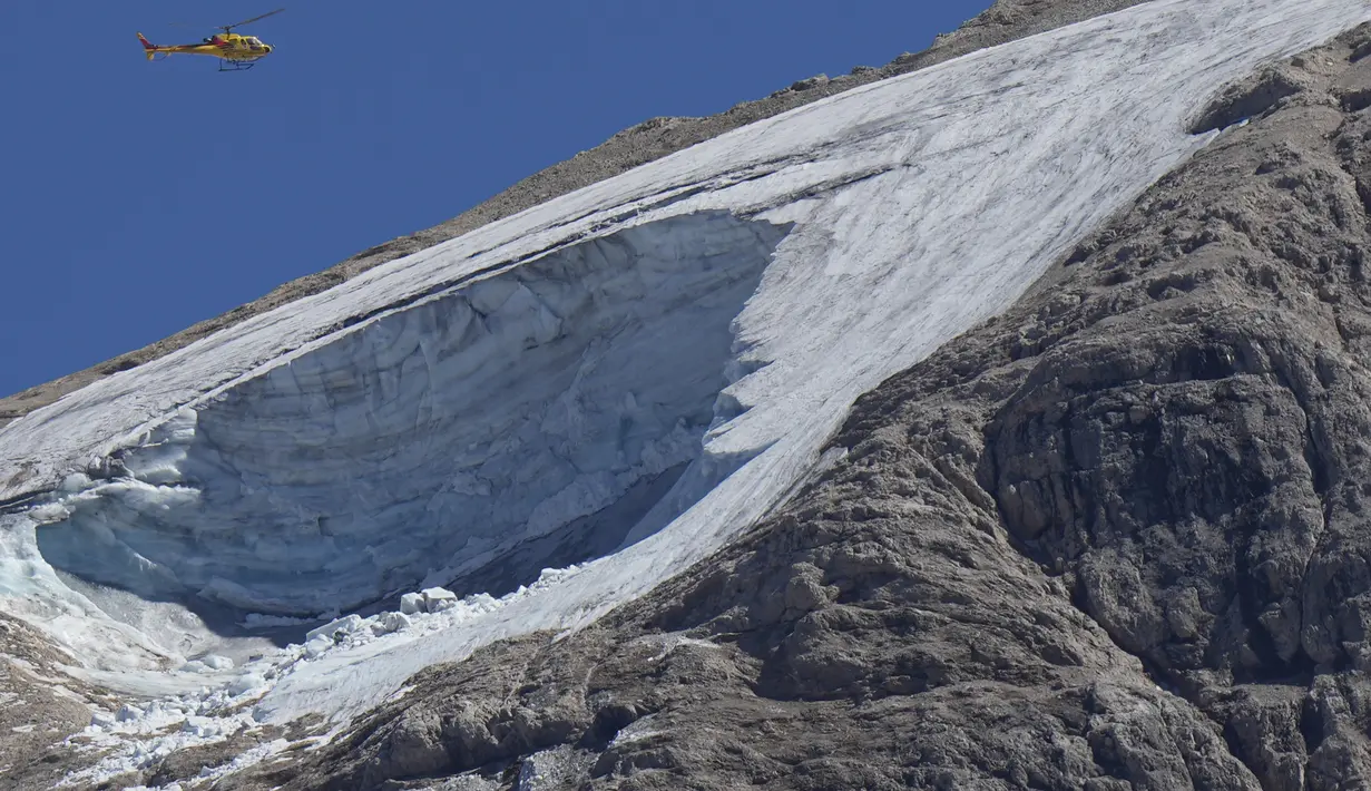 <p>Helikopter penyelamat terbang di atas gletser Punta Rocca yang runtuh dekat Canazei di Pegunungan Alpen Italia di Italia utara (4/7/2022). Tim penyelamat mengatakan kondisi lereng bawah dari gletser, yang telah mencair selama beberapa dekade, masih terlalu tidak stabil. (AP Photo/Luca Bruno)</p>