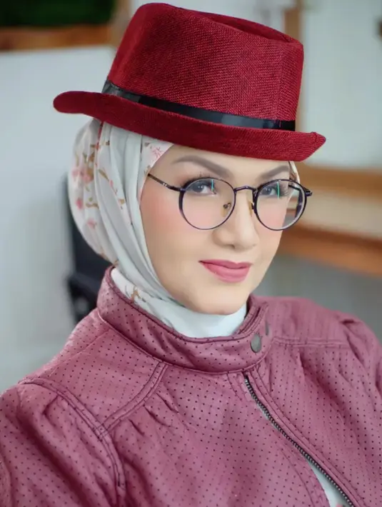 Tuty Wibowo kini berhijab. Salah satu foto menampilkannya berkerudung putih motif floral yang dipadu dengan topi merah bundar plus jaket berwarna senada namun beda tone. Gara-gara lagunya enak didengar, Tuty Wibowo ditetapkan sebagai salah satu anak Bunda Corla. Artis lain yang juga dianggap anak Bunda Corla di antaranya Nikita Mirzani dan Annisa Pohan. (Foto: Dok. Instagram @tuty_wibowo).