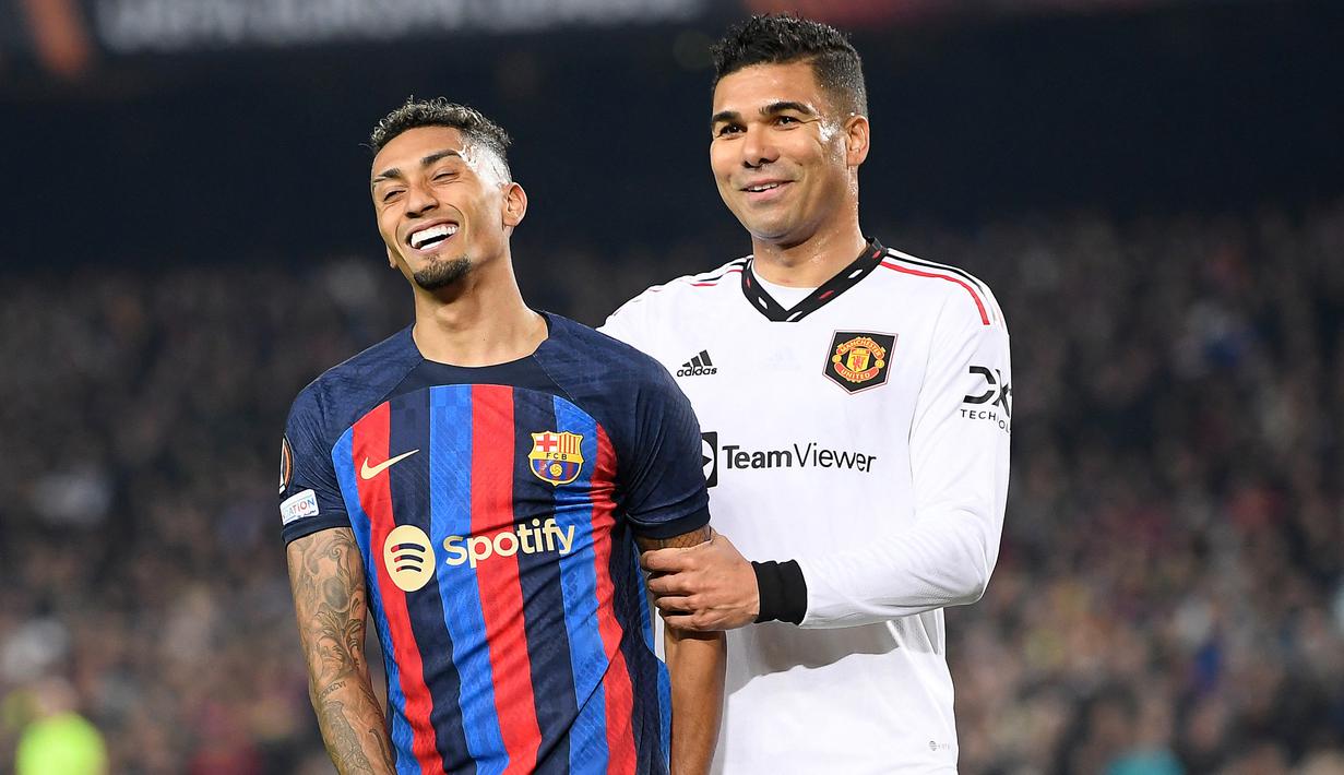 Ekspresi pemain Barcelona, Raphinho (kiri) dan pemain MU, Casemiro dalam pertandingan leg pertama play-off babak gugur Liga Europa 2022/2023 yang berlangsung di Camp Nou, Jumat (17/2/2023). (AFP/Josep Lago)
