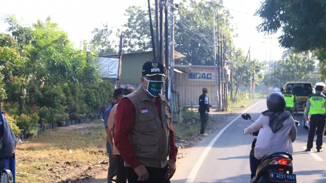 Petugas berjaga di titik check point PSBB di Kota Bekasi. (Liputan6.com/Bam Sinulingga)