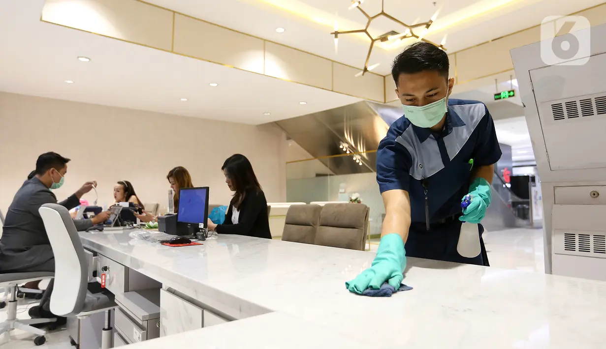 Petugas membersihkan meja customer dengan mendisinfeksi sejumlah fasilitas di Lippo Malls Puri, Jakarta, Jumat (06/3/2020). Petugas juga membersihkan di beberapa titik yang banyak dilalui atau digunakan pengunjung seperti tombol lift, hand rail eskalator. (Liputan6.com/Fery Pradolo)
