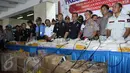 Petugas Bea dan Cukai dan Porles Metro Bandara memperlihatkan barang bukti Narkoba yang disita dari para tersangka di Bandara Soetta, Tangerang, Kamis (27/8/2015).  Petugas berhasil menyita sekitar 94 kg dan 12.189 ekstasi. (Liputan6.com/Gempur M Surya)