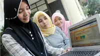 JALUR MANDIRI: Dari kiri, Rachel Fattama, Fadilah Fauziah dan Lila Robandria, membuka website pendaftaran PTN jalur mandiri Universitas Airlangga Surabaya, Selasa (10/7). (RADAR SURABAYA/ANDY SATRIA)