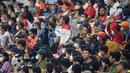 Seorang penonton menerikkan dukungan saat laga International Youth Championship 2021 antara Indonesia All Stars U-20 melawan Barcelona U-18 di Jakarta International Stadium, Jakarta, Rabu (13/04/2022). (Bola.com/Bagaskara Lazuardi)