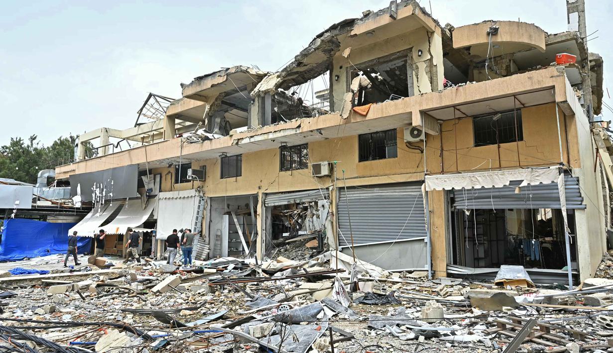 Kebahagiaan menyelimuti kembalinya mereka ke rumah, meski harus dihadapkan pada kerusakan fisik infrastruktur yang signifikan akibat serangan udara Israel. Tampak dalam foto, warga memeriksa puing-puing bangunan yang hancur saat kembali ke kota Nabatieh, Lebanon Selatan pada Sabtu 18 April 2026. (FADEL itani/AFP)