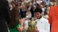 Putri Wales Catherine mempersembahkan trofi pemenang kepada Carlos Alcaraz dari Spanyol setelah mengalahkan petenis Serbia Novak Djokovic dalam pertandingan final Wimbledon 2023 di All England Tennis Club, Wimbledon, London, Inggris, Minggu (16/7/2023). (foto:&nbsp;Byline / Source / CreditAdrian DENNIS / AFP)