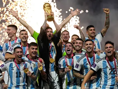 Pemain Argentina Lionel Messi bersama rekan setimnya mengangkat trofi juara usai mengalahkan Prancis pada pertandingan sepak bola final Piala Dunia 2022 di Stadion Lusail, Lusail, Qatar, 18 Desember 2022. Argentina menang 4-2 dalam adu penalti setelah pertandingan berakhir imbang 3 -3. (AP Photo/Martin Meissner)