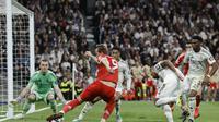 Momen striker Bayern Munchen Harry Kane melakukan shooting ke gawang Real Madrid yang dikawal Andriy Lunin. (Oscar DEL POZO / AFP)