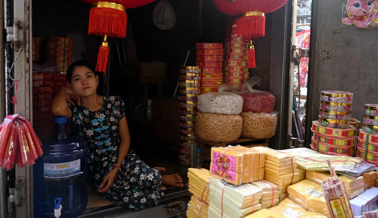 Seorang penjual menunggu pelanggan di tokonya jelang Tahun Baru Imlek di Distrik Pecinan Yangon, Myanmar, 18 Januari 2023. Tahun Baru Imlek 2023 yang disebut sebagai Tahun Kelinci akan jatuh pada tanggal 22 Januari. (STRINGER/AFP)