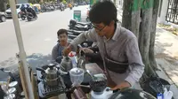 Achmad Yasin sedang meracik kopi di kedai sepeda motor miliknya di pinggir Jalan Jaksa Agung Suprapto, Kecamatan Mojoroto, Kota Kediri. (Liputan6.com/ Dian Kurniawan)