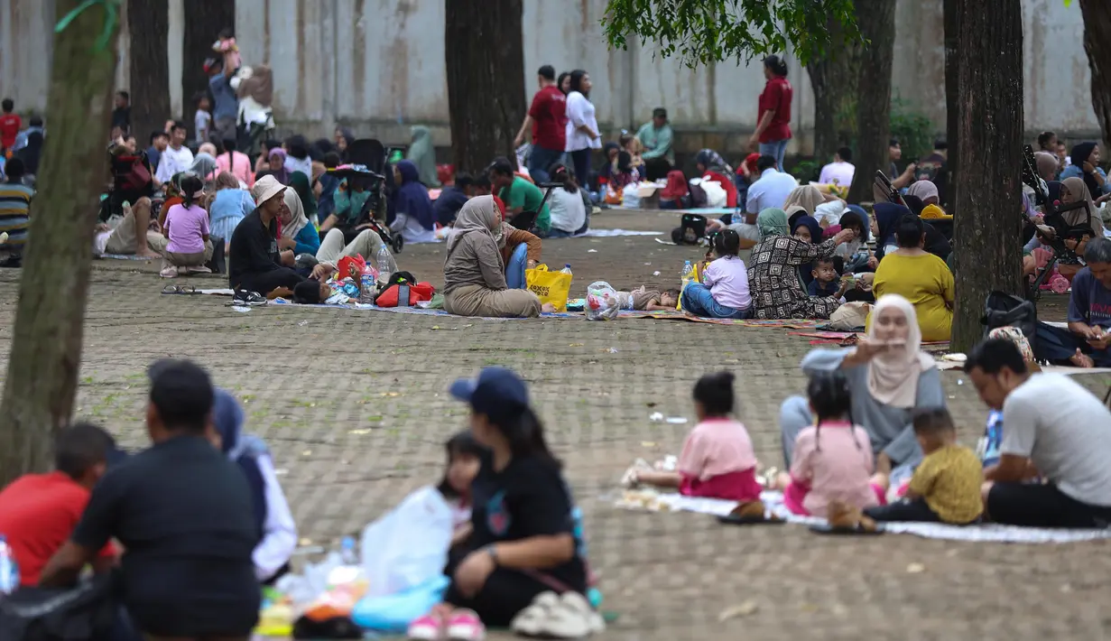 Ketika waktu istirahat siang tiba, banyak keluarga membentangkan tikar di bawah pohon rindang untuk menikmati makan bersama. (Kapanlagi.com/Budy Santoso)