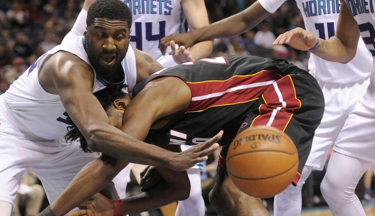 Pemain Miami Heat, Justise Winslow (tengah)  berebut bola dengan pemain Charlotte Hornets, Roy Hibbert (kiri) pada laga NBA di Spectrum Center, (29/12/2016). Hornets menang 91-82. (Reuters/Sam Sharpe-USA TODAY Sports)