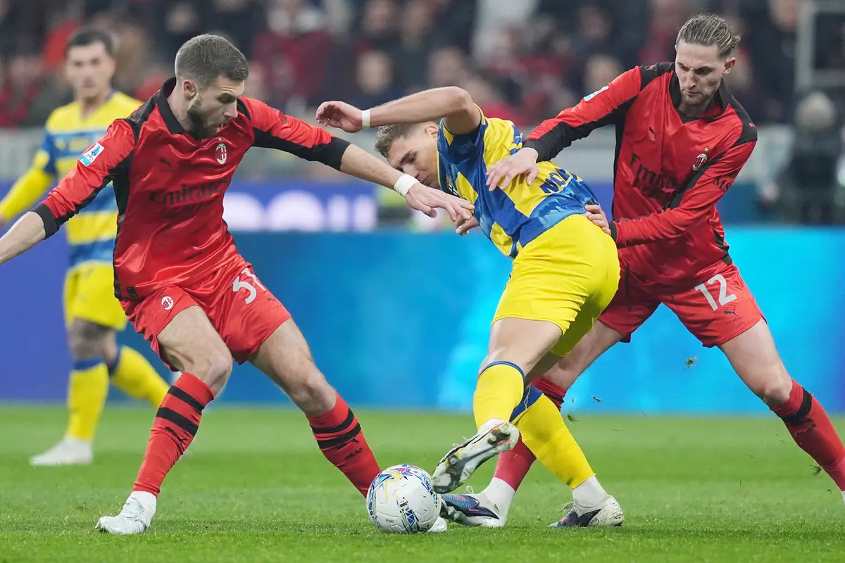 Pemain Parma Mateo Pellegrino mendapat tekanan dari dua pemain AC Milan, Strahinja Pavlovic dan Adrien Rabiot