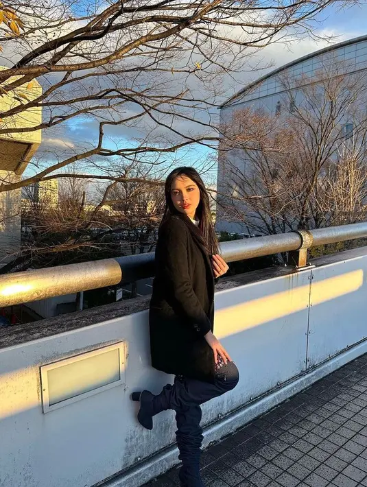 Menyesuaikan cuaca dingin di Jepang, Lyodra kerap tampil dalam balutan long coat di atas turtleneck putih. @lyodraofficial.
