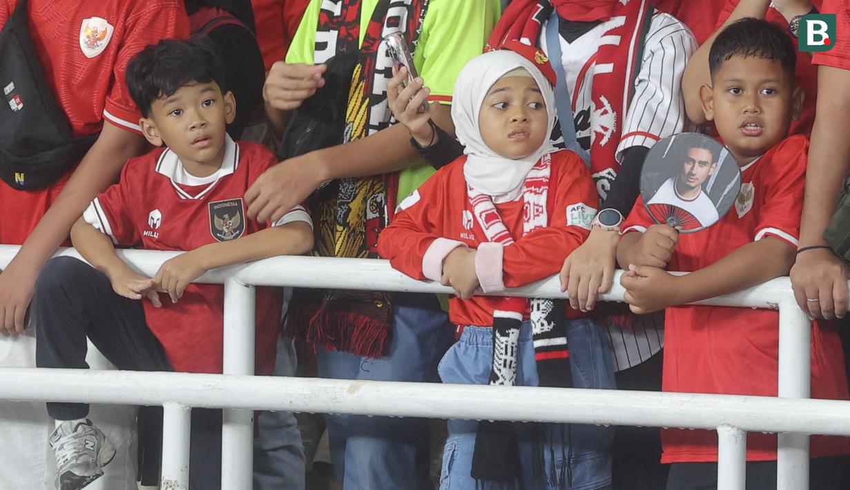 Suporter cilik tampak kecewa saat Timnas Indonesia kalah dari Jepang pada laga Grup C putaran ketiga Kualifikasi Piala Dunia 2026 Zona Asia di SUGBK, Jakarta, Jumat (15/11/2024). Skuad Garuda menyerah empat gol tanpa balas. (Bola.com.M Iqbal Ichsan)