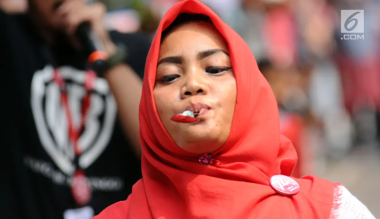 Salah satu peserta lari kelereng berjalan sambuil menjaga keseimbangan saat mengikuti lomba di kawasan Jalan Jaksa, Jakarta, Kamis (17/8). Lomba diadakan untuk memeriahkan HUT RI ke-72. (Liputan6.com/Helmi Fithriansyah)