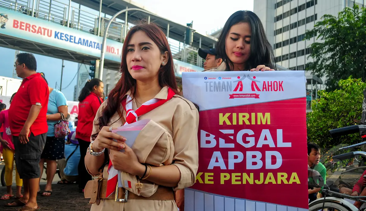 Kelompok masyarakat yang menamakan diri @temanahok menggelar aksi galang petisi 'Kirim Begal APBD Ke Penjara' di depan Bundaran HI atau arena Car Free Day, Jakarta, Minggu (8/3/2015). (Liputan6.com/Yoppy Renato) 