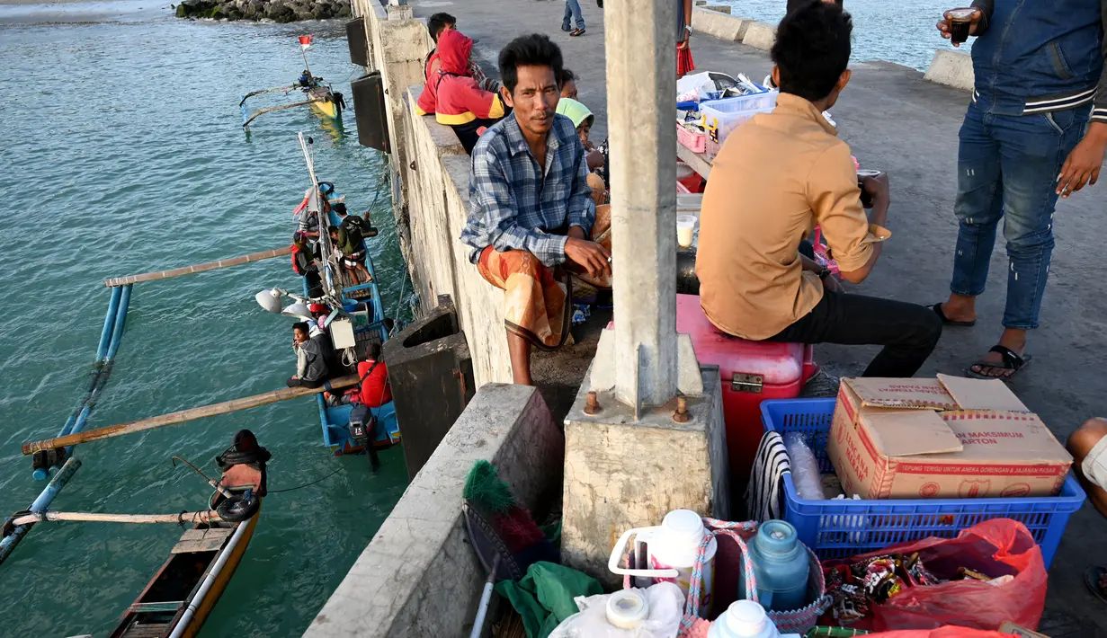 Sejumlah nelayan berbincang sebelum pergi memancing ikandi Kedonganan, Denpasar, Bali (15/7/2019).  Desa Kedonganan terkenal dengan sektor Perikanan, dan juga Pantai Kedonganan yang indah. (AFP Photo/Sonny Tumbelaka)