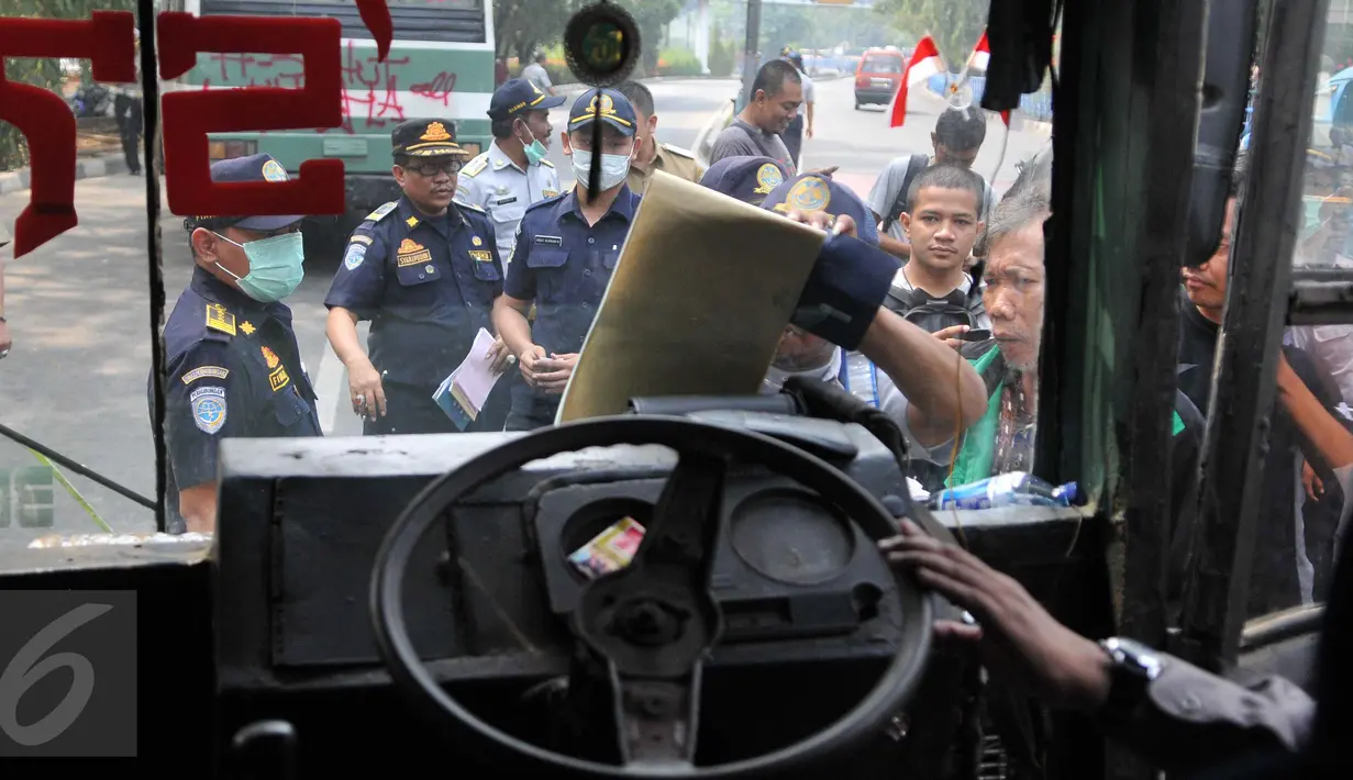 Sebuah mobil umum ditilang oleh Polisi saat razia di kawasan Terminal Kp. Rambutan, Jakarta (6/10/15). Pemeriksaan tersebut untuk menghidari angka kecelakaan dan mengurangi polusi. (Liputan6.com/Gempur M Surya)