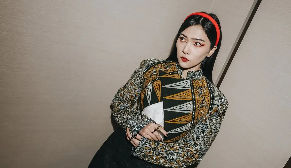 Penampilan feminin Isyana ditutup dengan rok hitam panjang dan platform heels berwarna merah mencolok [@isyanasarasvati]