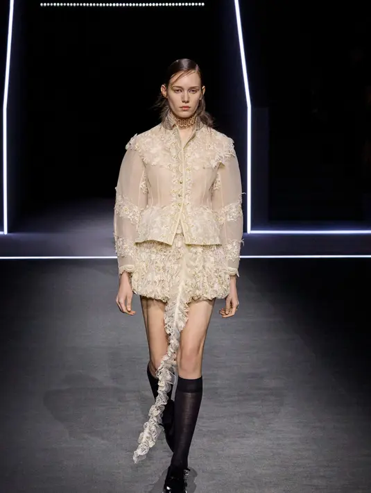 Koleksi ini menampilkan kerah frill yang bisa dilepas, memberikan fleksibilitas dalam gaya. Inspirasi ini berasal dari tokoh Orlando dalam novel Virginia Woolf, yang menggambarkan perubahan identitas tanpa batasan waktu atau gender. Visualisasi koleksi ini juga didukung oleh Robert Wilson, dengan permainan warna gelap ke terang yang menunjukkan perubahan suasana.  [Dok/Dior],