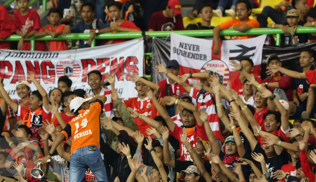Suporter Persija bernyanyi saat menyaksikan timnya berlaga melawan Madura United FC pada lanjutan Liga 1 di Stadion Patriot Candrabhaga, Bekasi, Kamis (4/5). Persija kalah 0-1. (Liputan6.com/Helmi Fithriansyah)