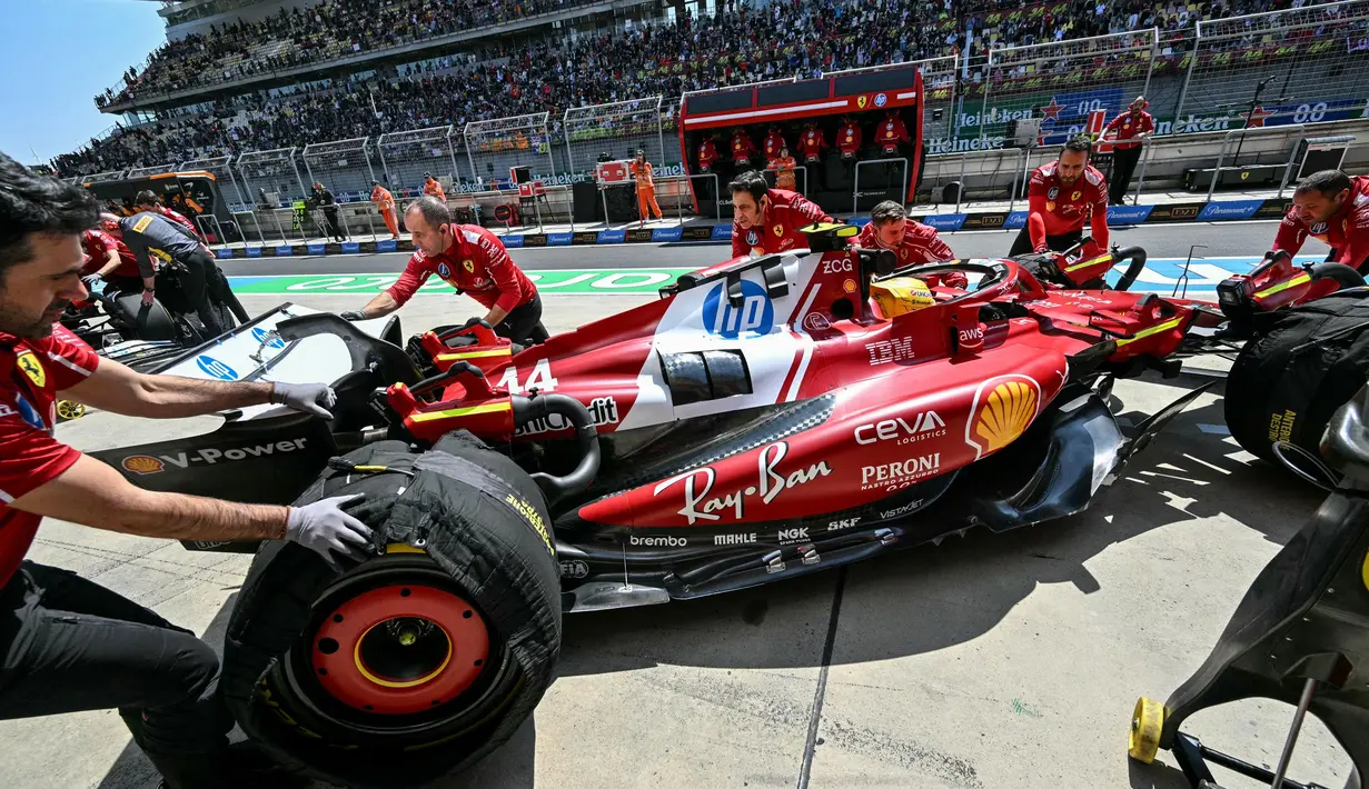 Mekanik mendorong mobil pembalap Ferrari asal Inggris, Lewis Hamilton, di pit saat sesi latihan pertama Formula Satu Grand Prix China di Sirkuit Internasional Shanghai pada 21 Maret 2025. (HECTOR RETAMAL/AFP)